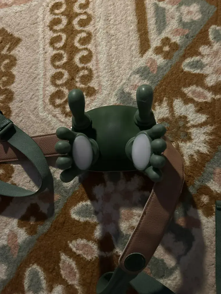 Il massaggiatore visto dall’alto su un tappeto a fantasia, le due piastre bianche rivolte verso l’alto